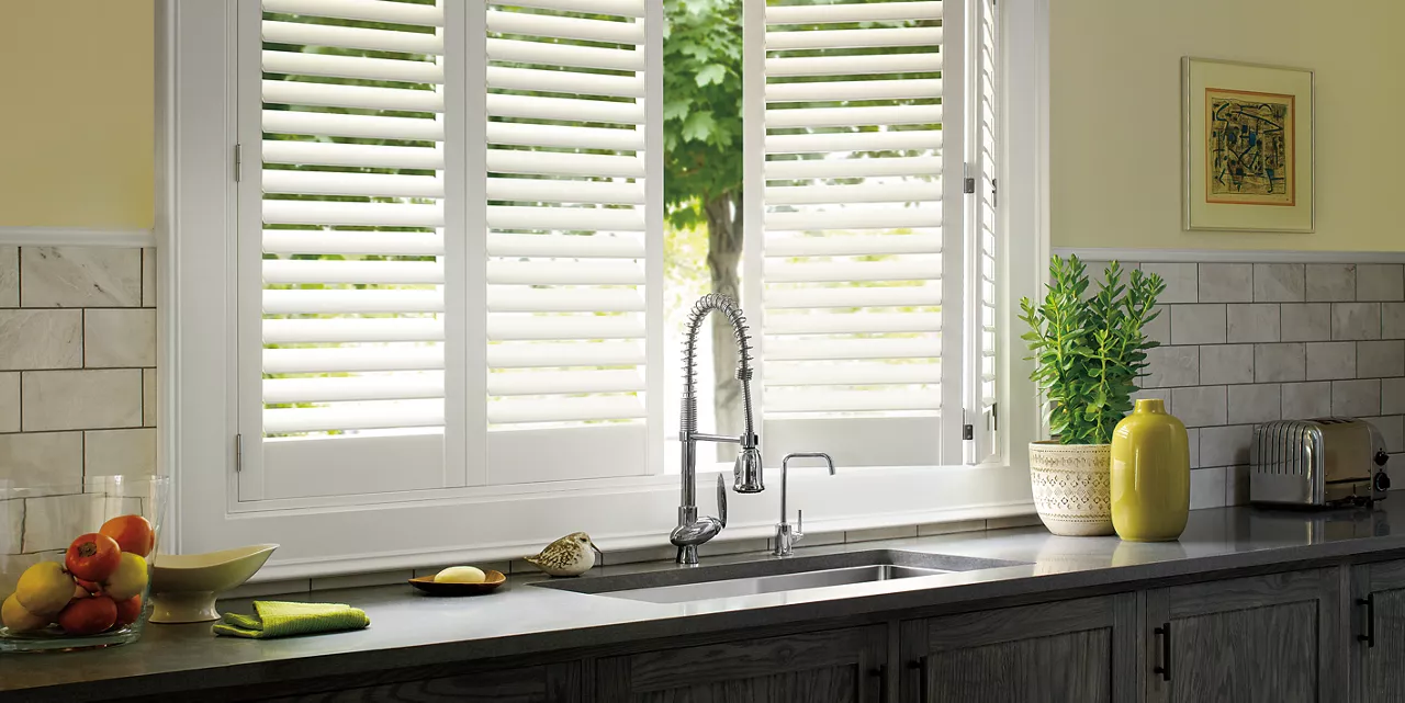 Palm Beach Polysatin vinyl shutters in shade Bright White. Window treatment for over the kitchen sink.