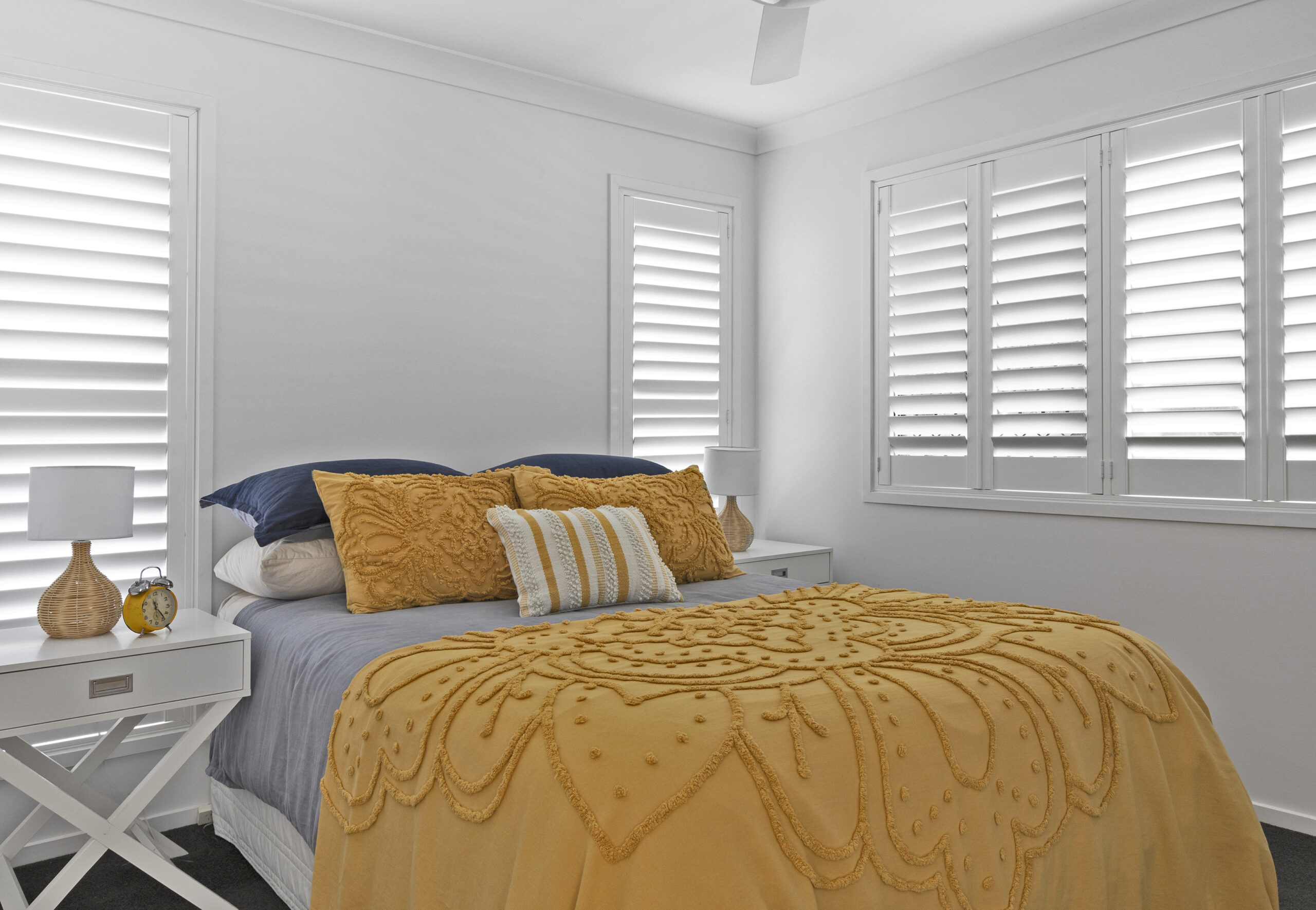 a bed with pillows and a fan in a room