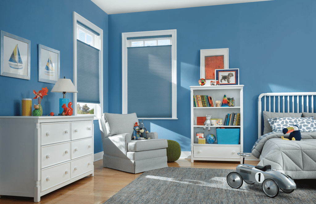 a room with blue walls and a white dresser and a chair