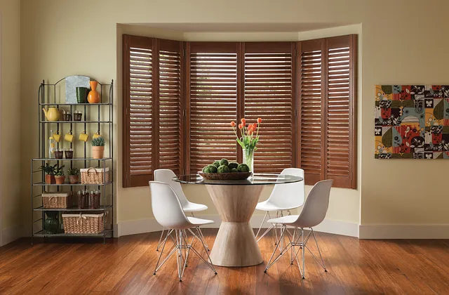 a table with chairs in a room with a window